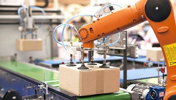 automatizacion mediante brazo robotico color naranja en fabrica industrial